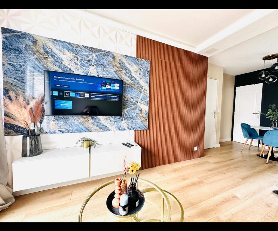 un soggiorno con una grande TV a parete di Appartement Louvres Premium - Roissy CDG a Louvres