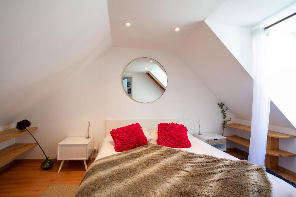een slaapkamer met een bed met rode kussens erop bij Charmante maison de pecheur in Ploubazlanec