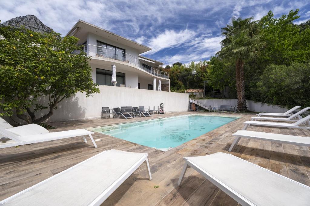 une piscine avec des chaises longues et une maison dans l'établissement Studio moderne tout confort, à La Valette-du-Var