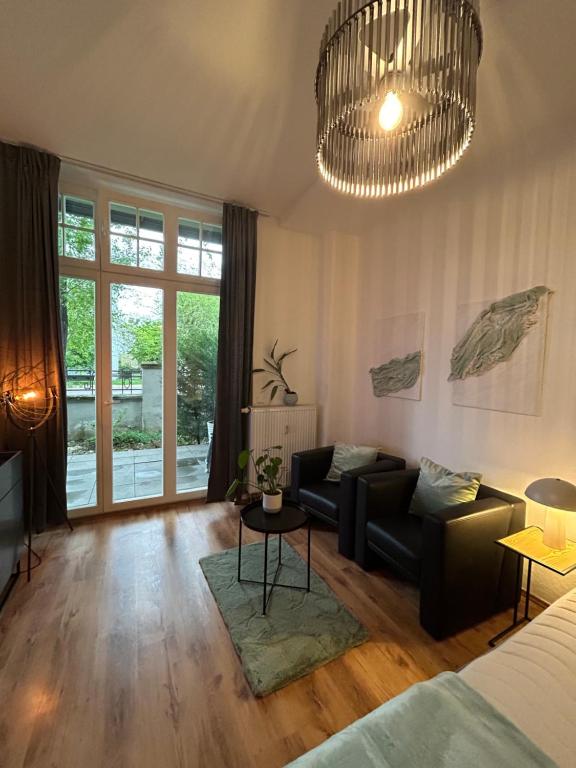 馬格德堡的住宿－Komfort Apartment mit Grill -Terrasse, Sky und Parkplatz，带沙发和吊灯的客厅