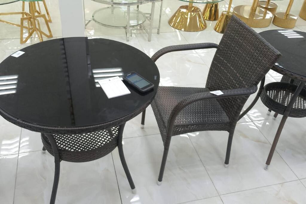 a black table with two chairs and a tablet on it at شقة ريم الوجة in Al Wajh