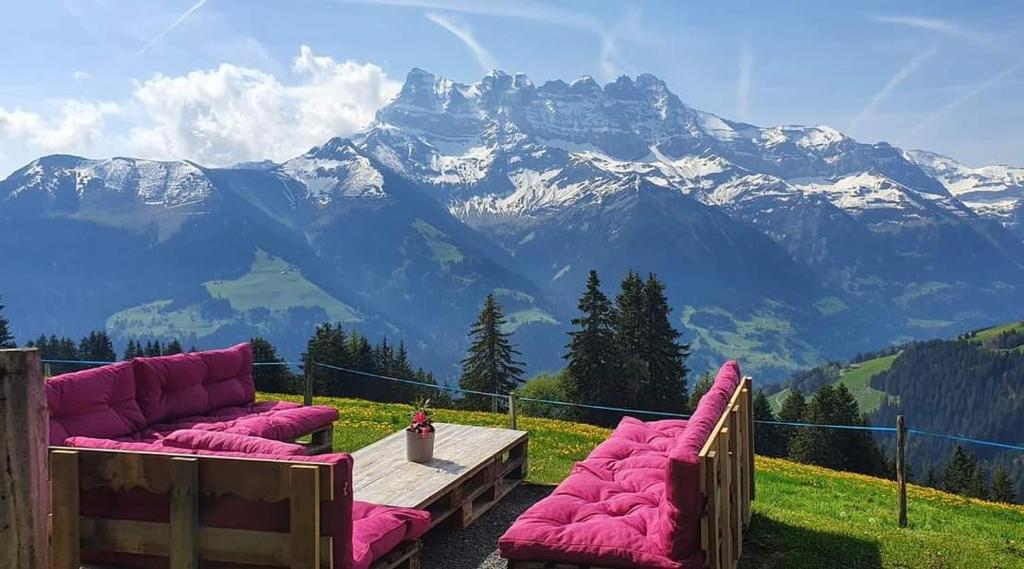 two couches sitting on a table with a view of a mountain at Chalet Chanso in Morgins