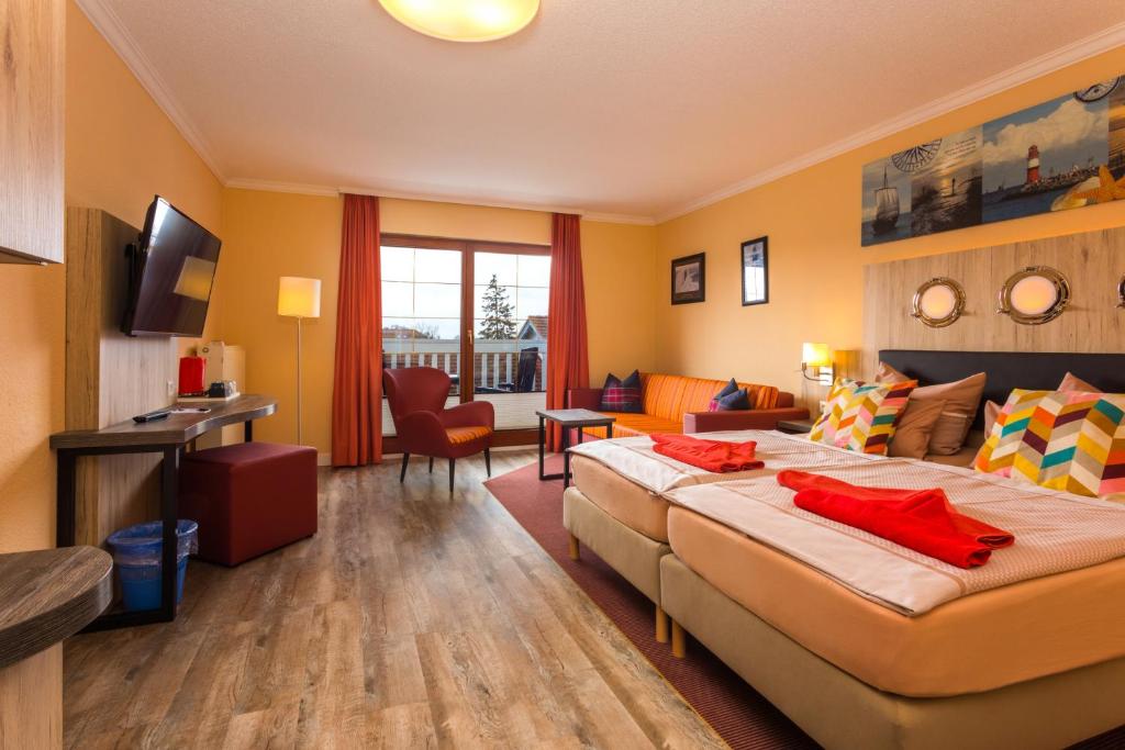 ein Schlafzimmer mit einem großen Bett und ein Wohnzimmer in der Unterkunft Hotel & Restaurant Hanse Kogge in Ostseebad Koserow