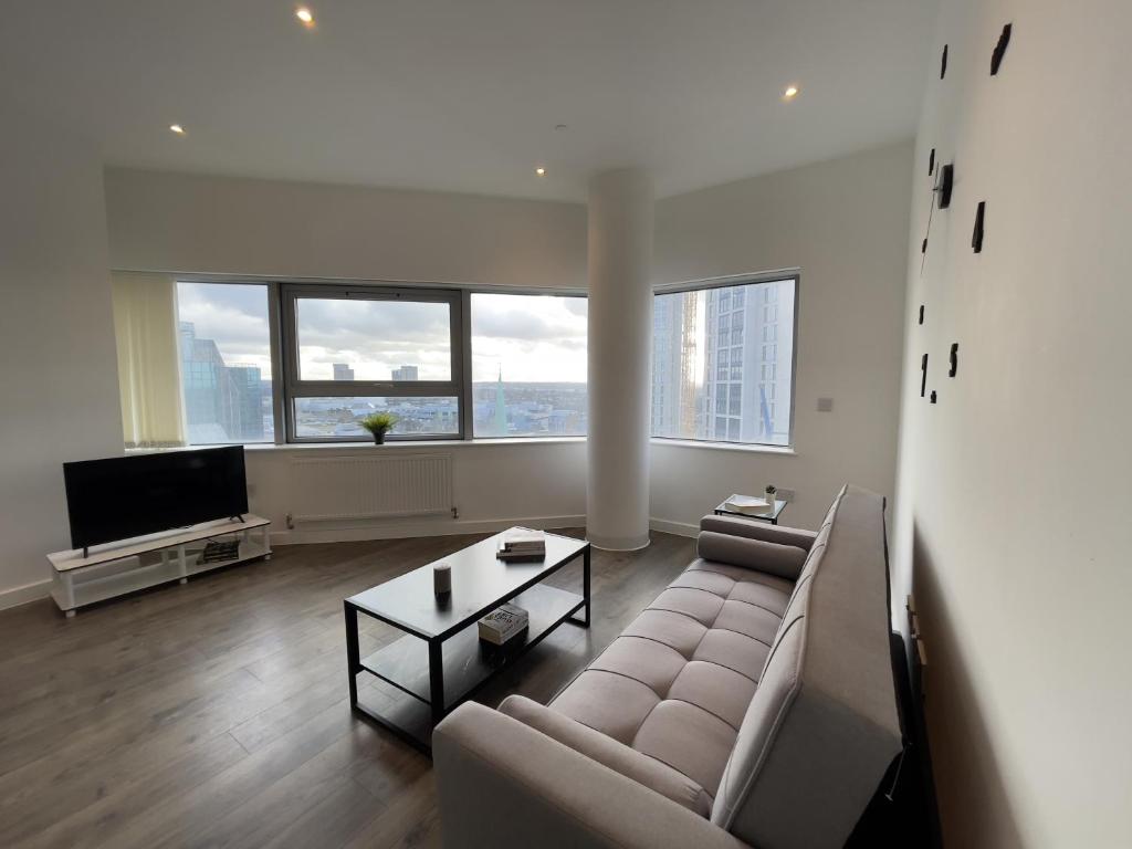 a living room with a couch and a tv at Bright & Spacious Flat In London in Croydon