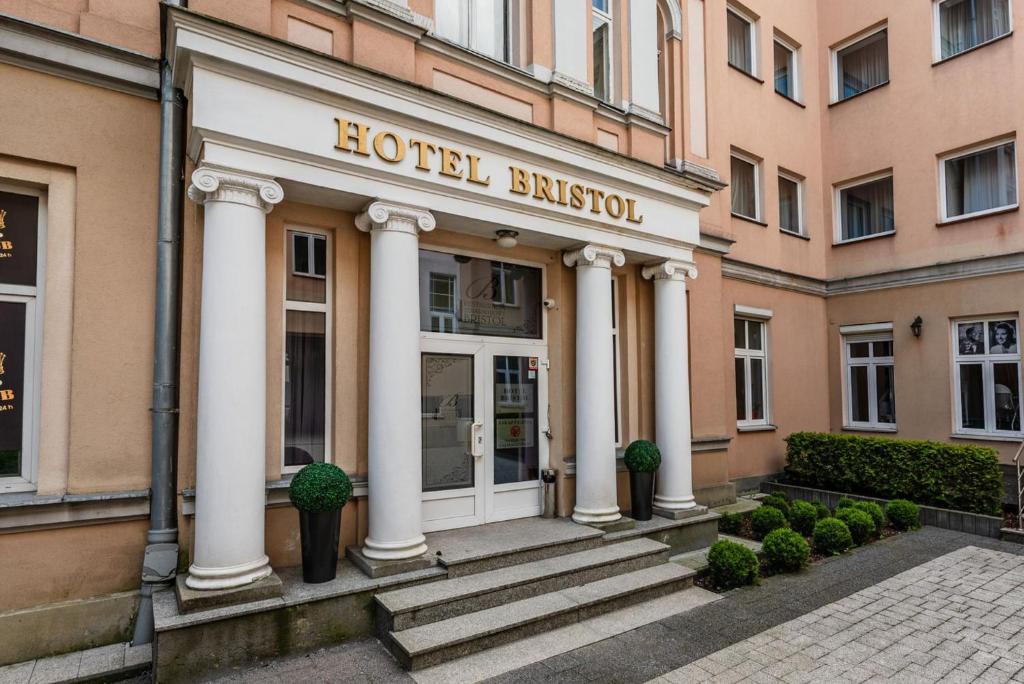 une entrée avec des colonnes blanches sur un bâtiment dans l'établissement Hotel Bristol, à Kielce