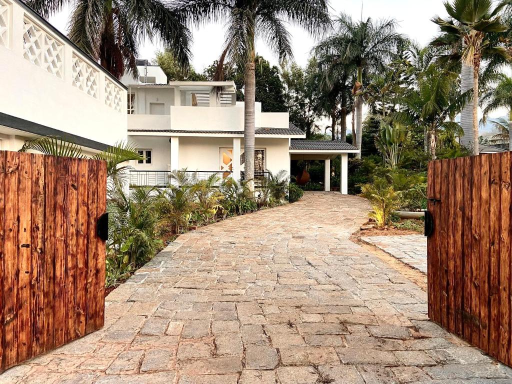 un vialetto che conduce a una casa bianca con palme di Sukoon Boutique Stays, Yelagiri a Yelagiri