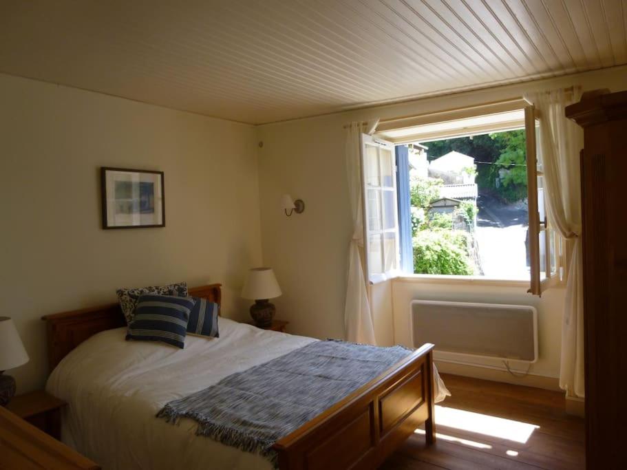 une chambre avec un grand lit et une fenêtre dans l'établissement Fisherman`s Cottage, à Mortagne-sur-Gironde