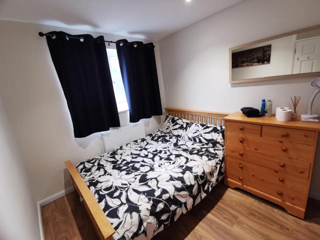 1 dormitorio con 1 cama en blanco y negro y vestidor en Private room in a lovely home en Bicester