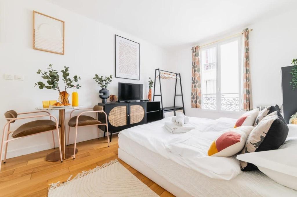 - un salon blanc avec un lit et une table dans l'établissement Studio fonctionnel et confortable - Paris 10 - 2P - FLAT-GUEST, à Paris