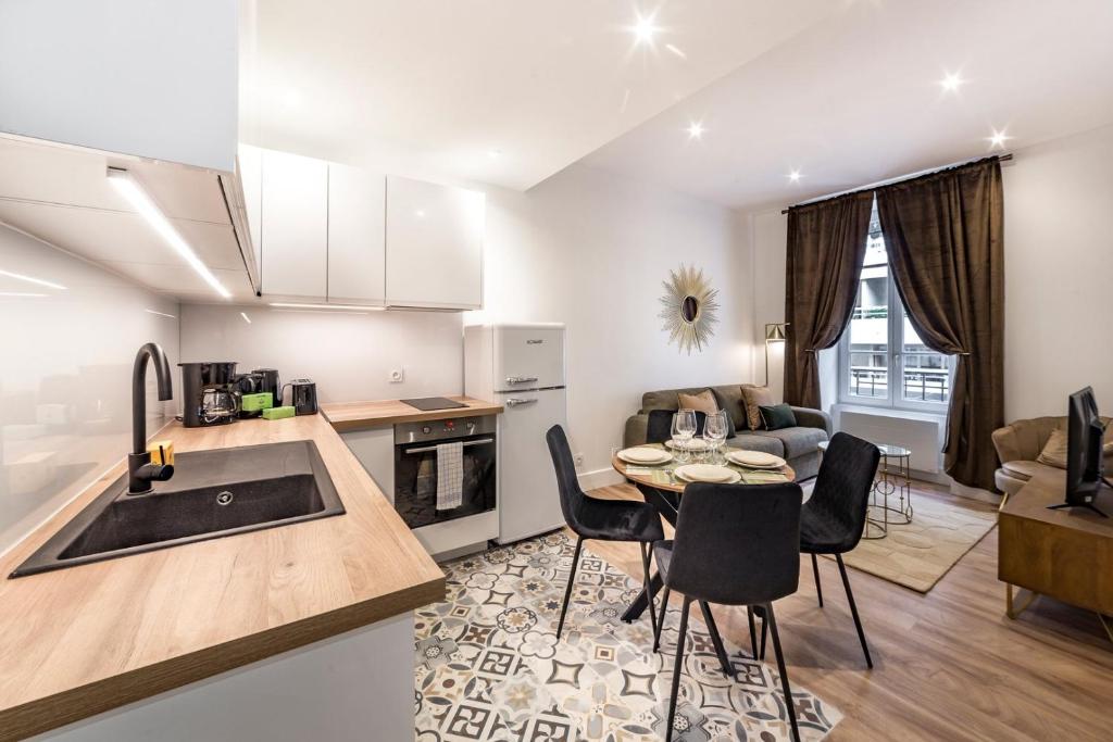 une cuisine et un salon avec une table et des chaises dans l'établissement Le Verlaine AIL, à Villeurbanne