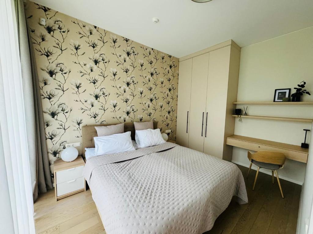 een slaapkamer met een bed met een bloemenbehang bij Moon apartment in Druskininkai