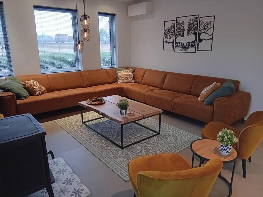 - un salon avec un canapé, une table et des chaises dans l'établissement Vakantiehuis Laurine, à Deinze