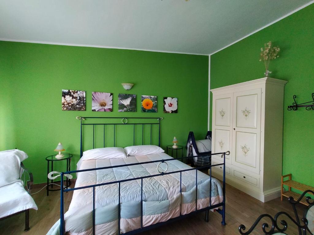 1 dormitorio con paredes verdes, 1 cama y armario blanco en Casa Vacanze TwentyMiles, en Castellana Sicula