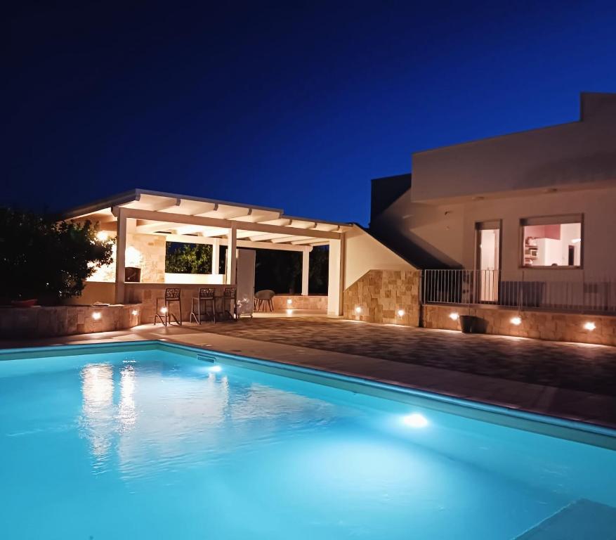 - une piscine en face d'une maison la nuit dans l'établissement Malia Holiday Villa, à Conversano