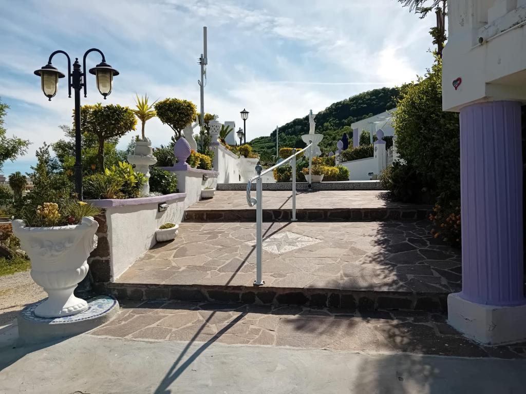 un patio con jarrones blancos y luces de la calle en Casa Vacanza Villa Lesto, en Isquia