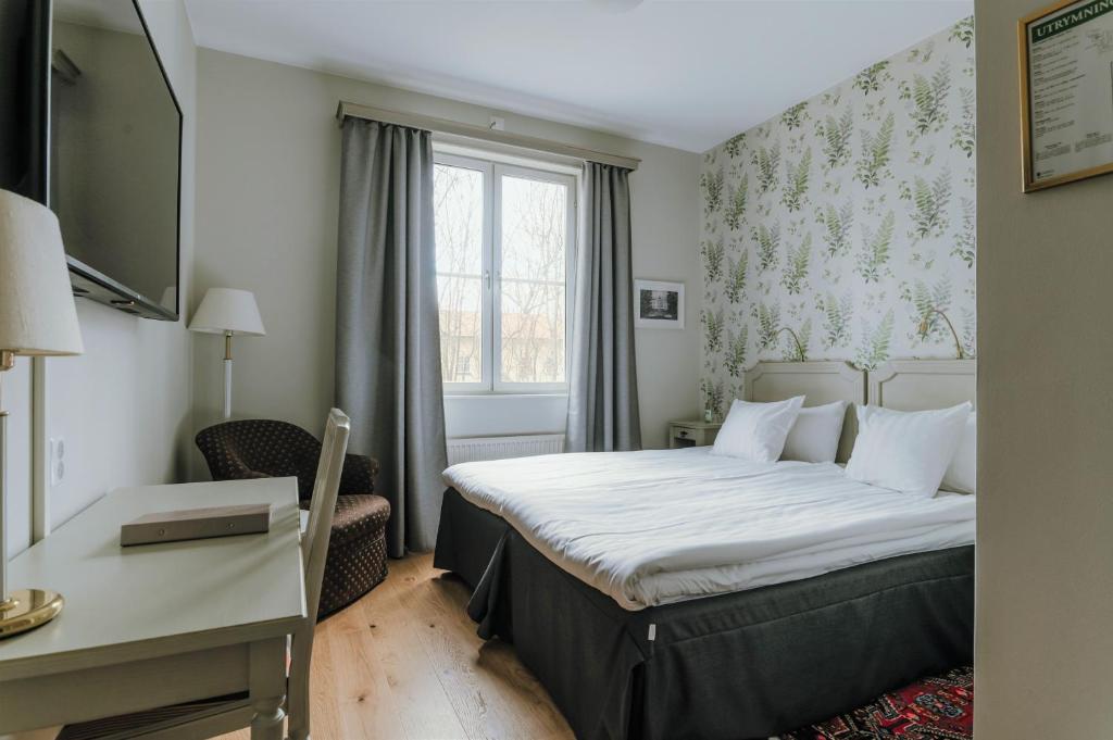 um quarto de hotel com uma cama e uma secretária em Haga Slott em Enköping