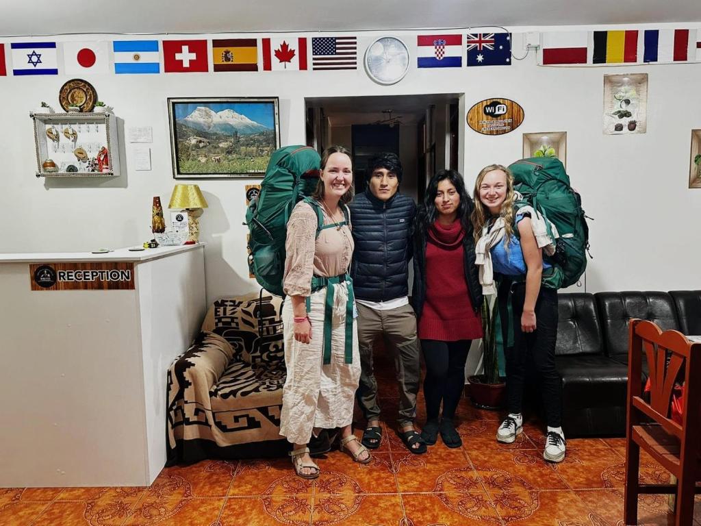 a group of people posing for a picture in a room at Yerupaja Mountain Hostel in Huaraz