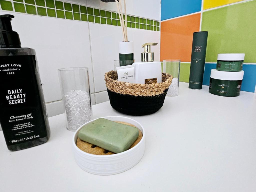 a bathroom counter with a container of soap and other products at Logement dans résidence - à 10 km du centre ville et à 5 minute du parlement européen avec parking gratuit in Hoenheim