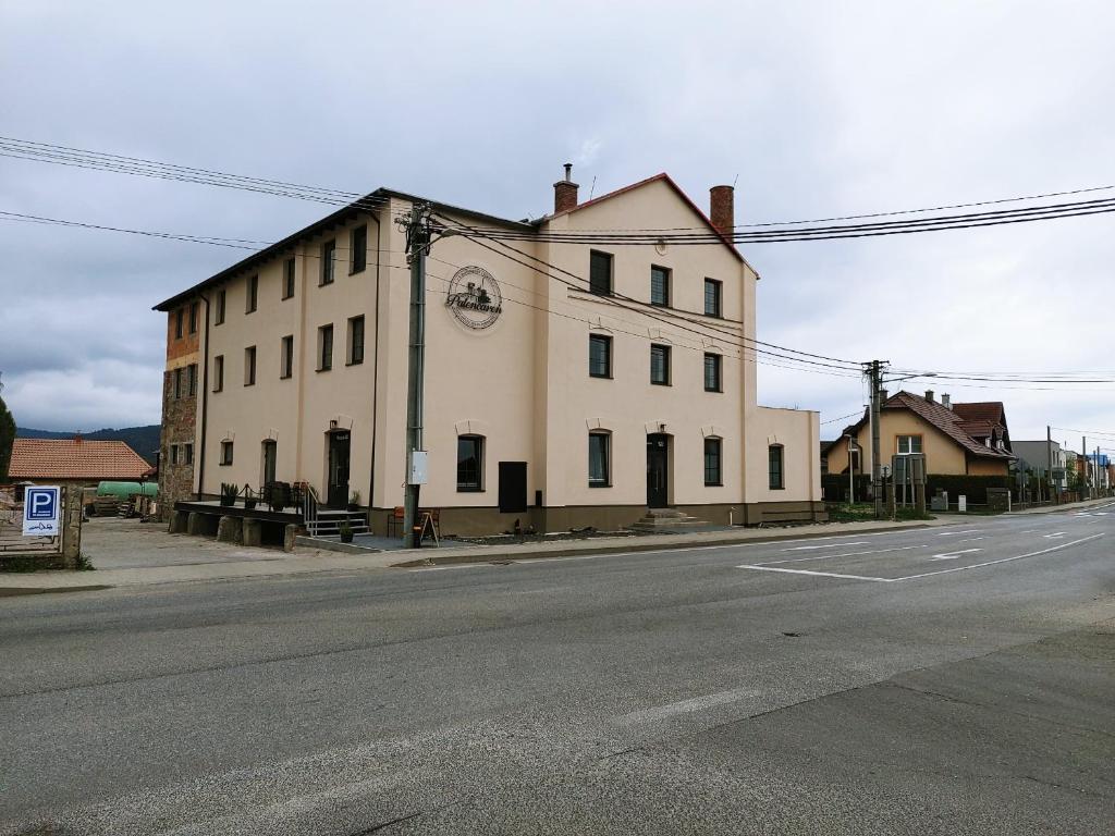 un grand bâtiment blanc sur le côté d'une rue dans l'établissement Palenčareň - Old Destilery, à Spišská Belá