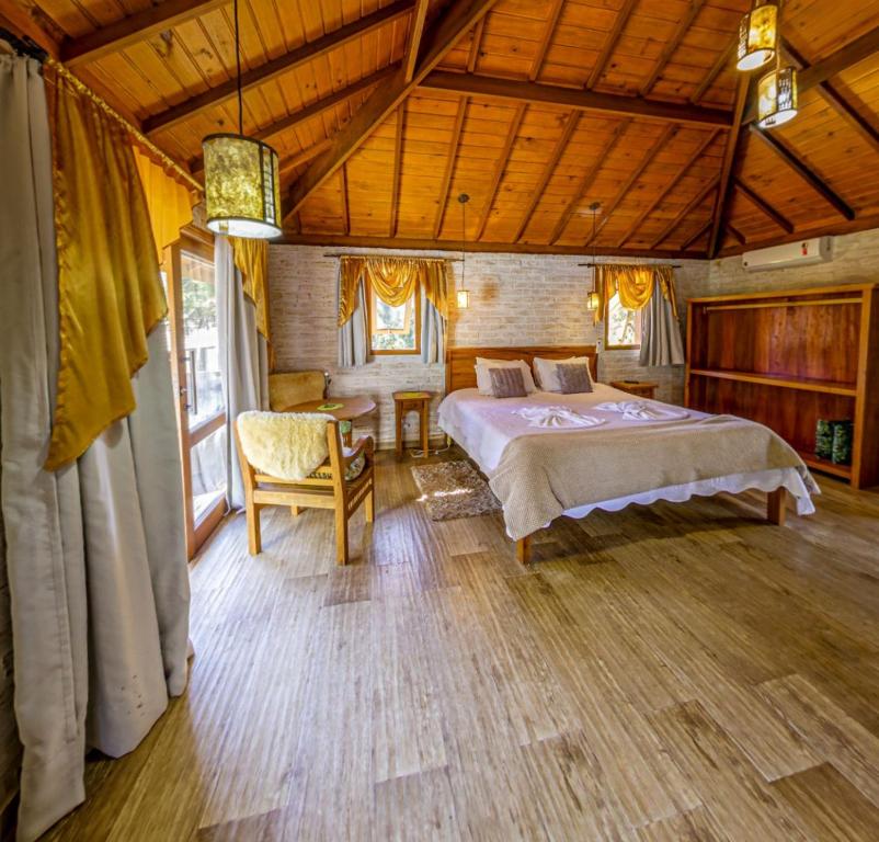 1 dormitorio con 1 cama y 1 silla en una habitación en Chalés pinha pinhão, en Monte Verde