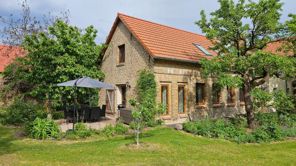 ein Haus mit einem Regenschirm davor in der Unterkunft Ferienhaus Pathe in Neuendorf bei Wendisch Buchholz