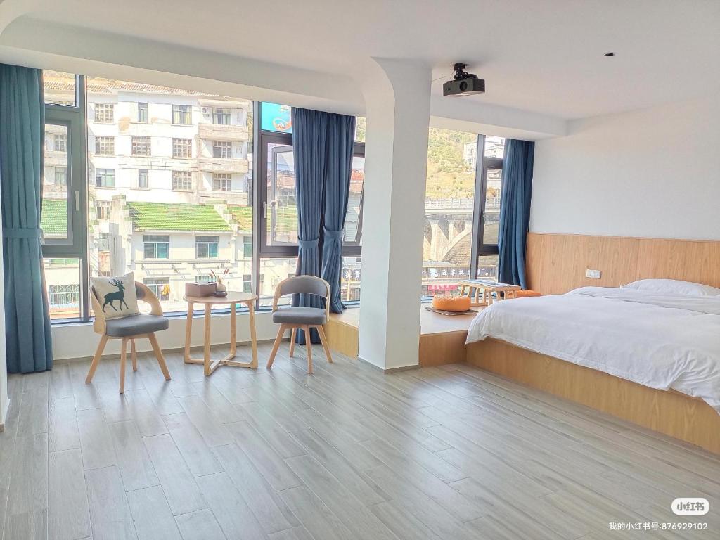 sypialnia z łóżkiem, stołem i krzesłami w obiekcie Huang Mountain Wangfeng Hotel w mieście Huangshan