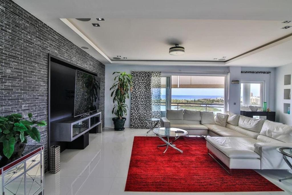 ein Wohnzimmer mit einer weißen Couch und einem roten Teppich in der Unterkunft Lovely 3-Bed Apartment in Maho in Maho Reef