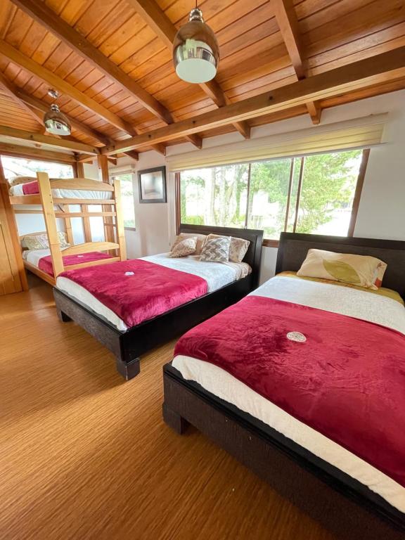 - une chambre avec deux lits et un plafond en bois dans l'établissement Hacienda Le Plus, à Quito