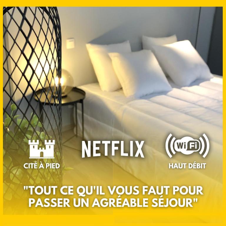 - un lit avec des oreillers blancs dans l'établissement City'IN Appart, à Carcassonne