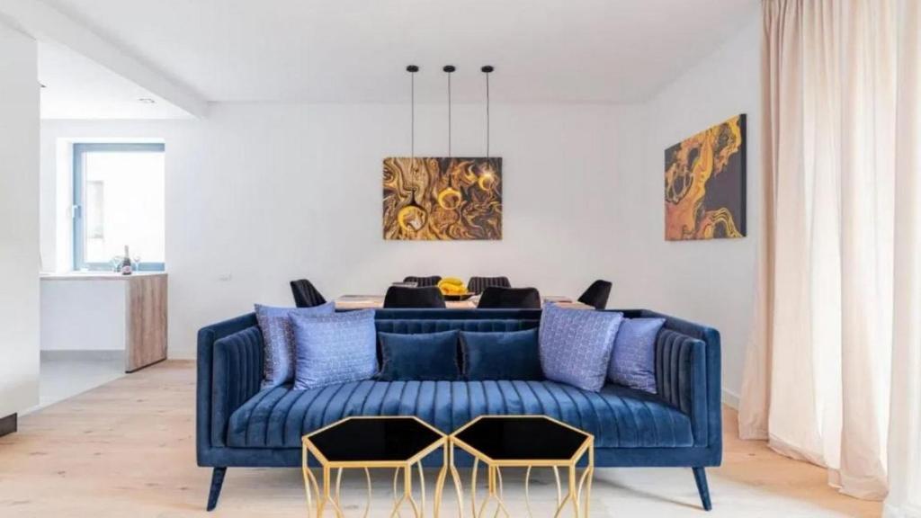 ein blaues Sofa im Wohnzimmer mit einem Tisch in der Unterkunft Turegatan Top Class Apartment in Stockholm