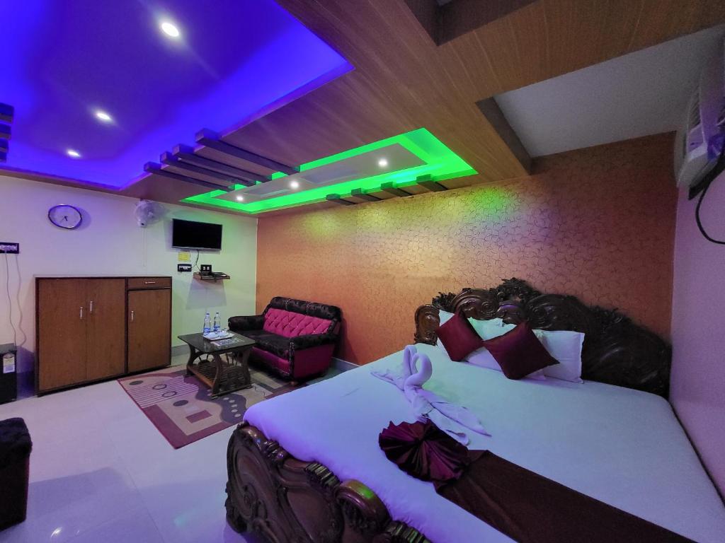 a bedroom with a large bed and a room with a couch at Abhishek Inn New Digha in Digha