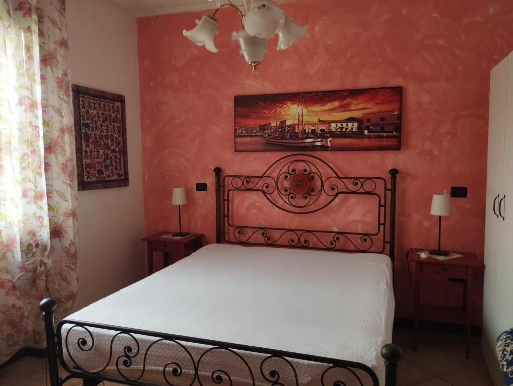 a bedroom with a bed and two night stands with lamps at Casa delle Rose Appartamento Gelsomino in San Mauro Pascoli