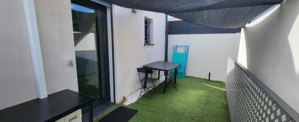 un balcon avec une table et des chaises dans un immeuble dans l'établissement Appartement à 200 m de l'Etang de Thau, à Mèze