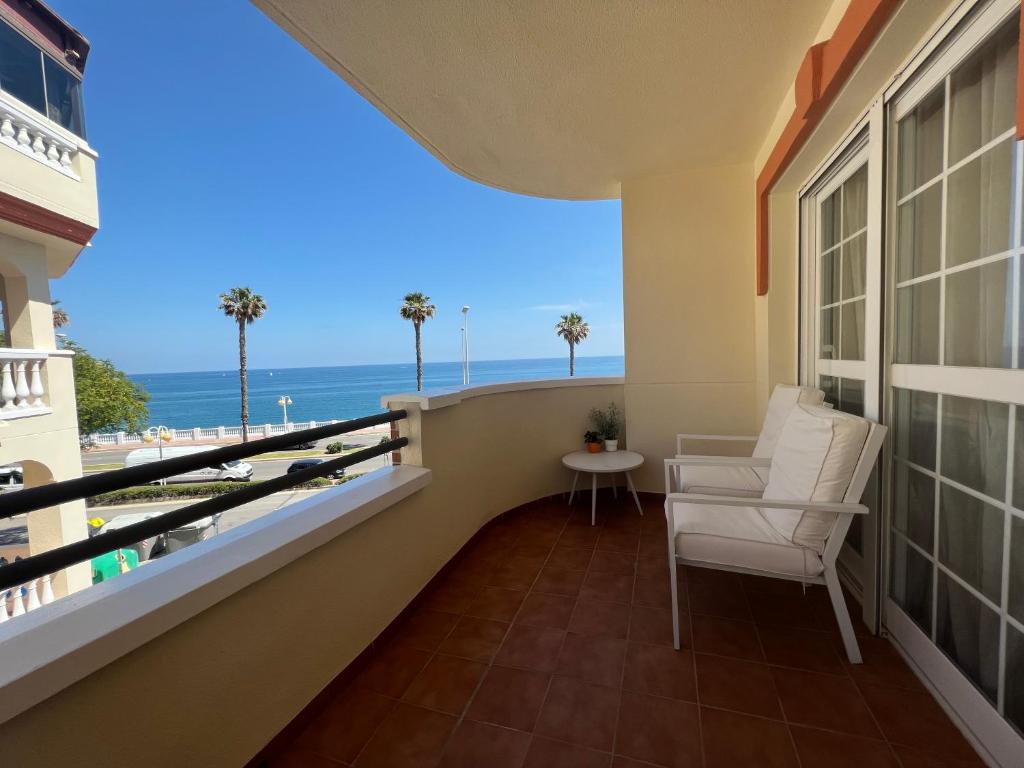 a balcony with a chair and a view of the ocean at Torreon del Mar in Benalmádena