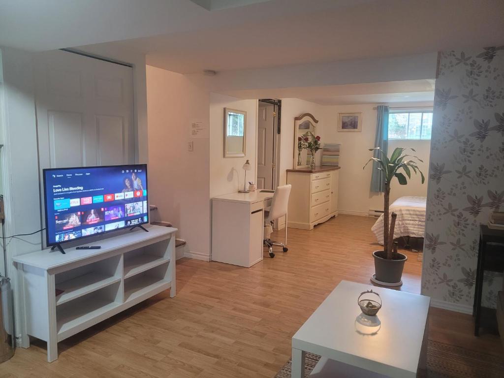 ein Wohnzimmer mit einem Flachbild-TV auf einem Stand in der Unterkunft logement,suite l arlequin in Vaudreuil-Dorion