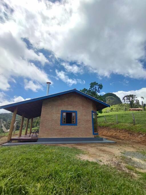 a small house in a field with a sky at Chalé Pedra Chanfrada 03 in Gonçalves