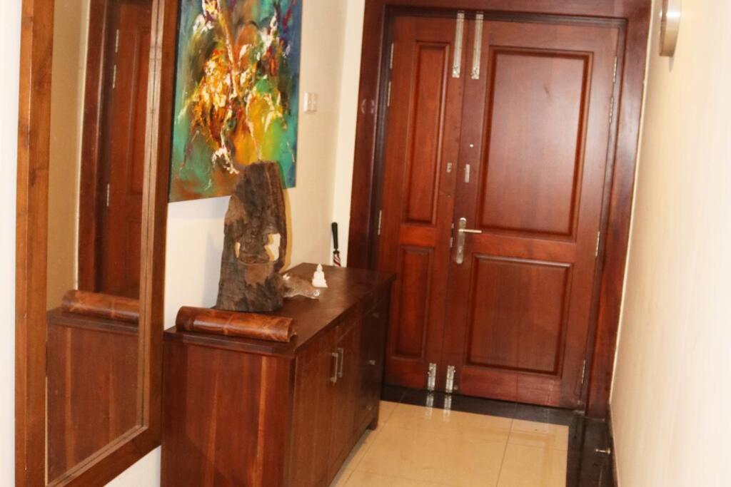 可倫坡的住宿－Entire 3 Bed Room Luxurious Apartment in Colombo 8，走廊上设有两扇木门,旁边设有雕像