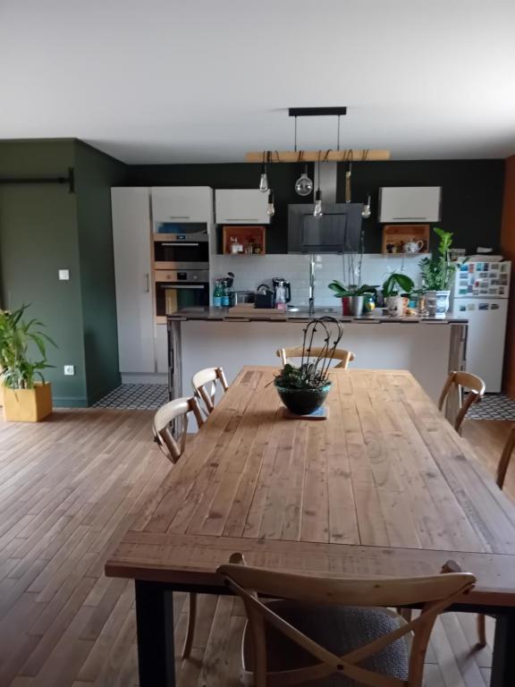 una mesa de madera en una habitación con cocina en Bois d'Yevre, en Vierzon