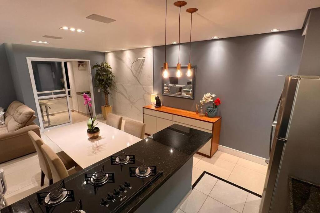 a kitchen with a black counter and a refrigerator at Apartamento Maravilhoso Perfeito in Sao Paulo