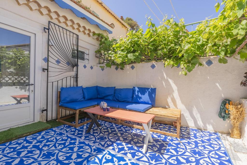 un canapé bleu et une table sur une terrasse dans l'établissement Belle Maison Bleu Azur, à Six-Fours-les-Plages