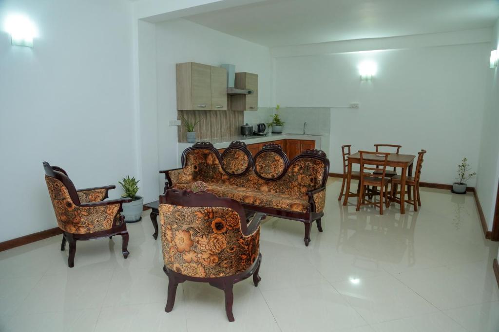 a living room with couches and a table and chairs at Kandy DOWNTOWN in Katugastota