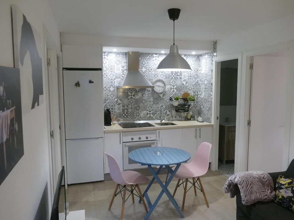 a kitchen with a blue table and pink chairs at Casita con encanto en Baiona a lado de las playas de Santa Marta y Ladeira in Baiona