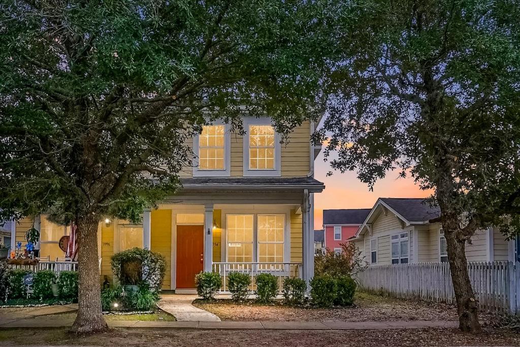 una casa con una porta gialla e una recinzione bianca di Lowcountry Oasis a Charleston