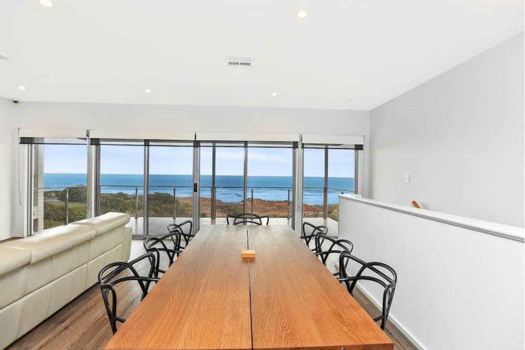 a dining room with a table and chairs and the ocean at Avaya Sellicks Beachfront Getaway- Wifi in Sellicks Beach