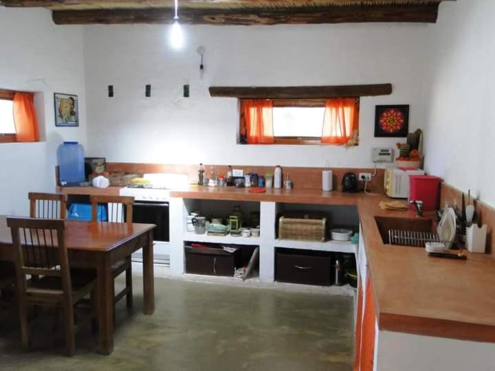a kitchen with a wooden table and a table and a dining room at El Paraiso in Tinogasta