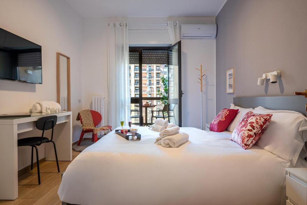 a bedroom with a white bed with towels on it at Bari incanto - 3 Bedroom Apartment & Free Parking in Bari