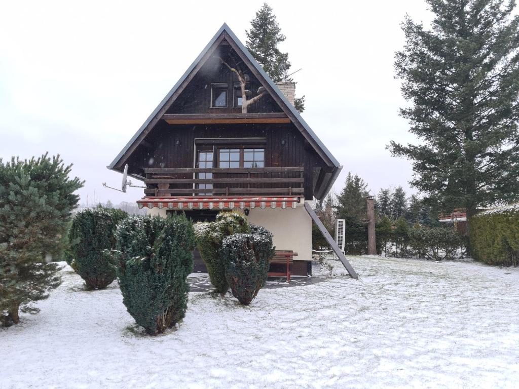 施騰貝克的住宿－chataugryšánků，雪中的房子,前面有灌木丛