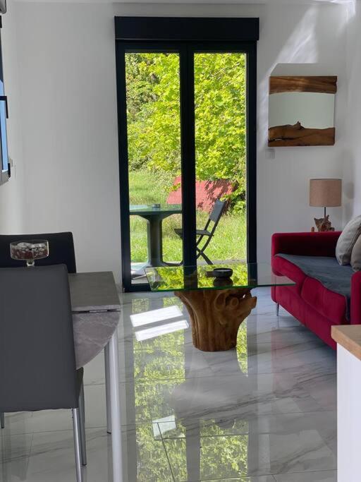 ein Wohnzimmer mit einem roten Sofa und einem Tisch in der Unterkunft Tiny House DALIA Jardin & forêt 10 min de la gare in Dammarie-les-Lys