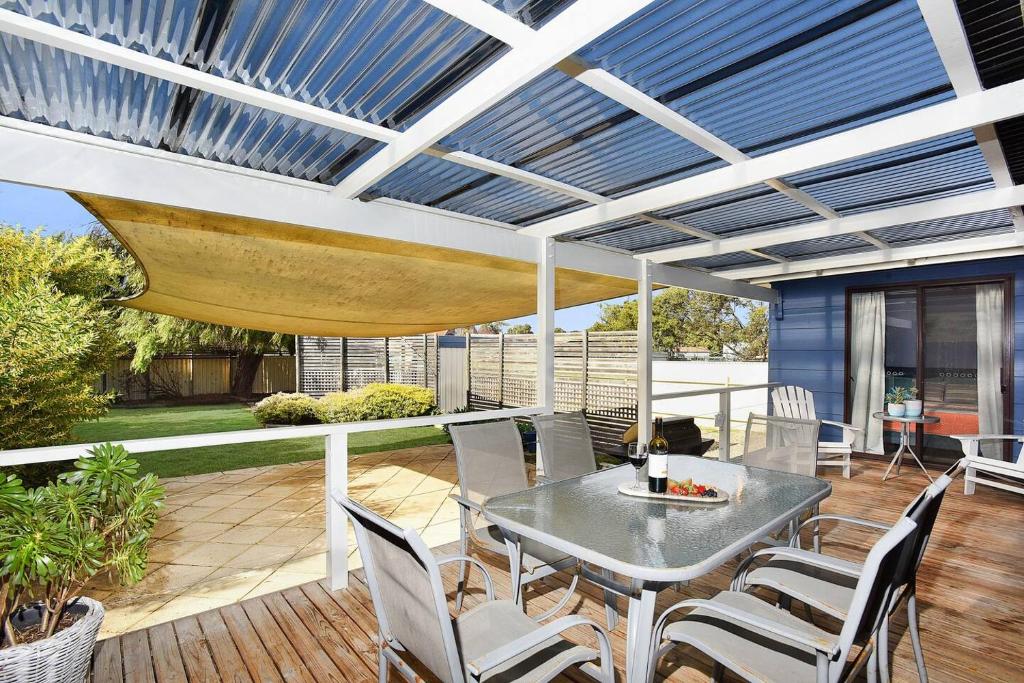 a patio with a table and chairs on a deck at Goolwa Blue Escape - Beach Spacious Wi-fi in Goolwa