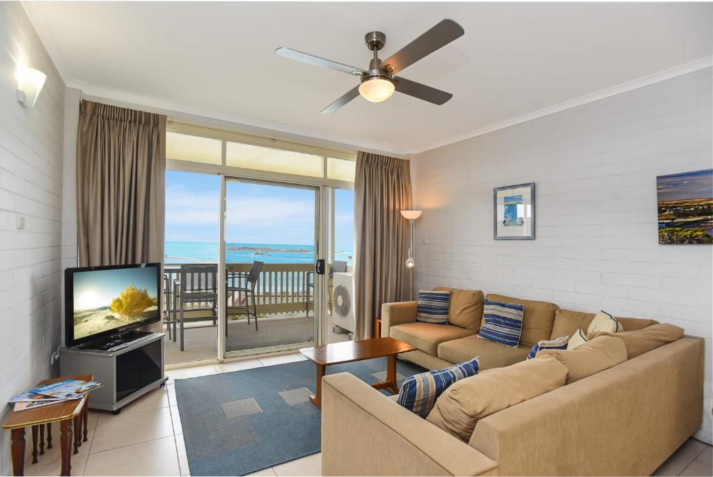 a living room with a couch and a flat screen tv at 'The Dolphins 7' - Beachfront View To Remember in Port Elliot